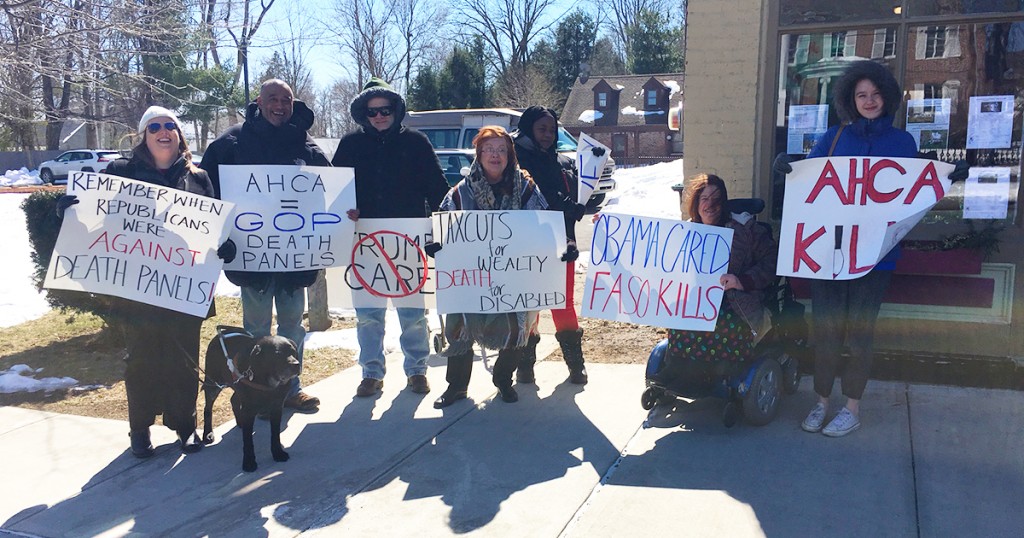 Protectors lined up with their large posters to show their protest against the cut to medicaid.