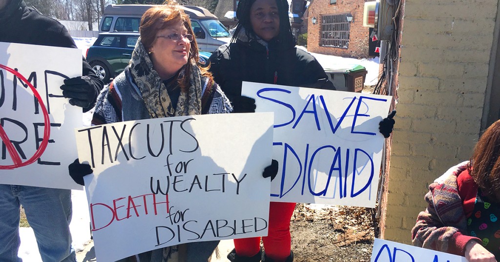 protestors holding up signages. One said, "Taxcuts for wealthy, Death for disabled." Another sign said, "Save Medicaid."