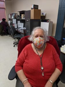 Picture of Ann Kaplow sitting in a chair with a face mask